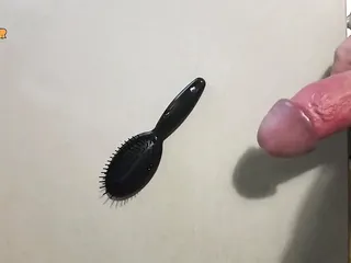 Jerking off on a small hairbrush, cumshot with a lot of cum from a big cock by an handjob.