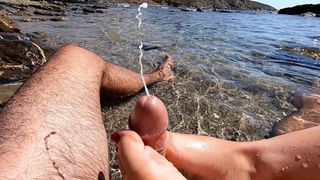 Amateur footjob with cumshot outdoors in a public beach