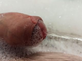 Close up pissing cock in the foam in bathtub