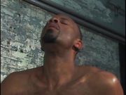 Two hot black men suck dick by a cement wall.